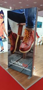 Portable SEG light box display with backlit shoe advertisement at retail trade show booth