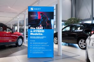 Portable SEG light box displaying SEAT e-HYBRID automotive branding in car dealership showroom