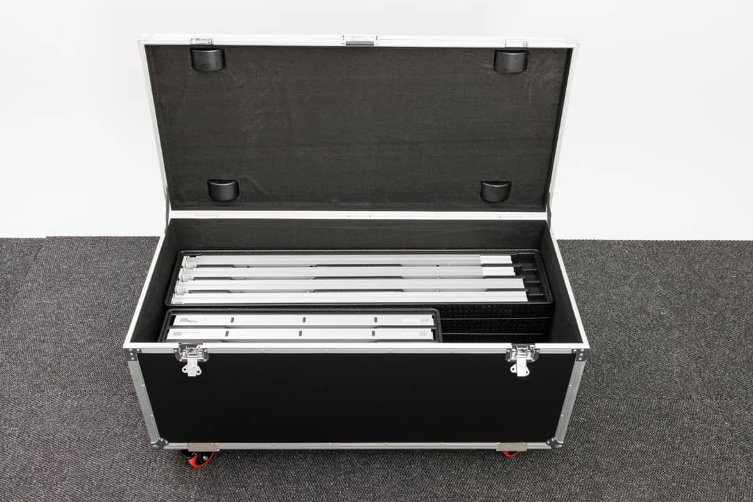Portable trade show display road case with modular aluminum frames and LED light box components inside