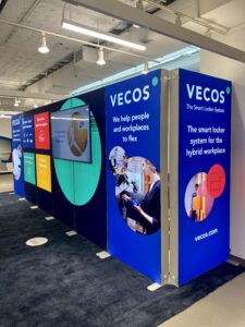Modular SEG light box trade show booth with backlit blue fabric graphics and branding for VECOS at exhibition
