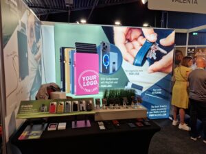 Backlit SEG trade show booth displaying custom branded promotional products with modular fabric graphic walls