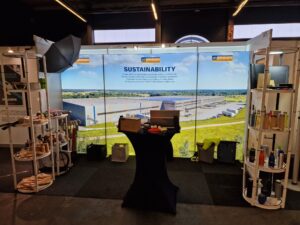 Modular SEG light box trade show booth with backlit sustainability banner and product display shelves