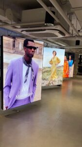 Large format SEG light box displays with backlit fashion graphics in modern retail showroom environment
