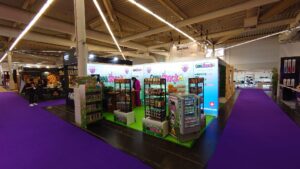 Modular backlit trade show display booth with SEG light box panels and product shelving at convention center