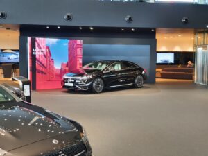 Backlit SEG light box display showcasing luxury vehicle in modern automotive showroom with vibrant graphics