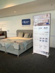 Portable SEG light box displaying bedding options in retail showroom with backlit graphics and modular frame system