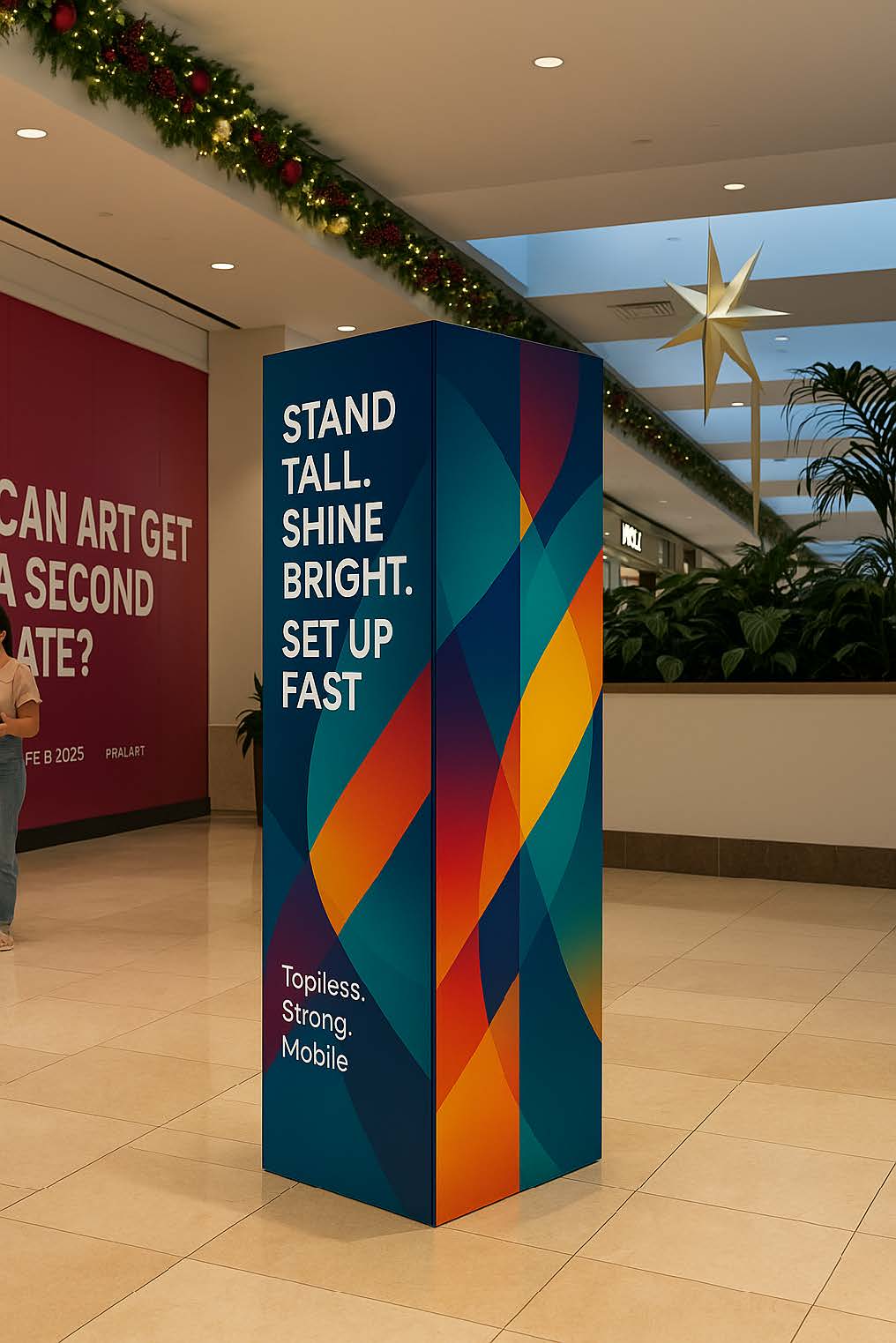 Tall portable SEG light box display with colorful geometric graphics in shopping mall during holidays